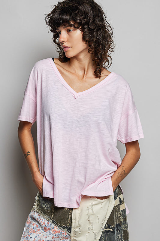 Woman wearing a light pink t-shirt against a plain background