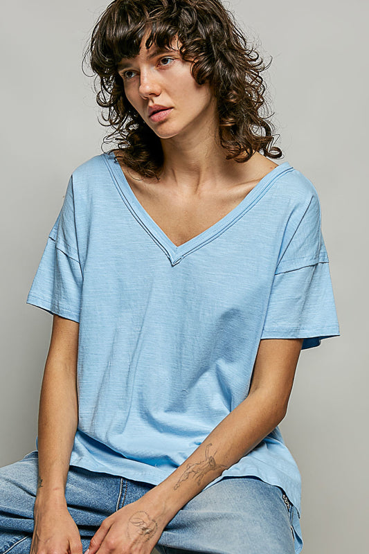 Woman wearing a light blue t-shirt against a gray background