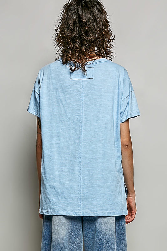 Person wearing a light blue t-shirt and jeans against a plain background