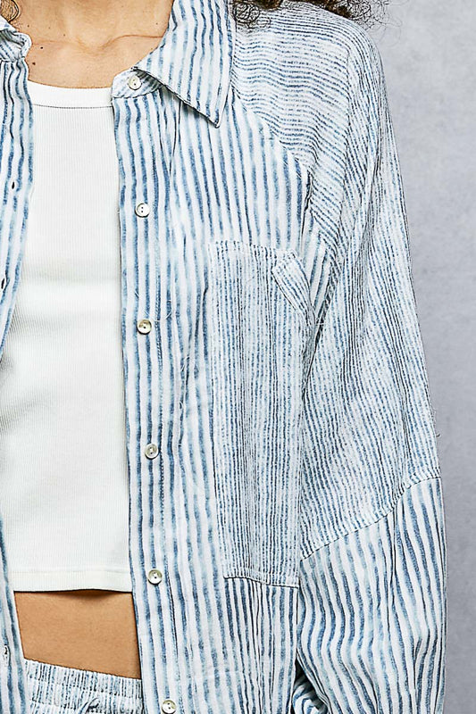 Blue and white striped shirt worn by a person on a gray background