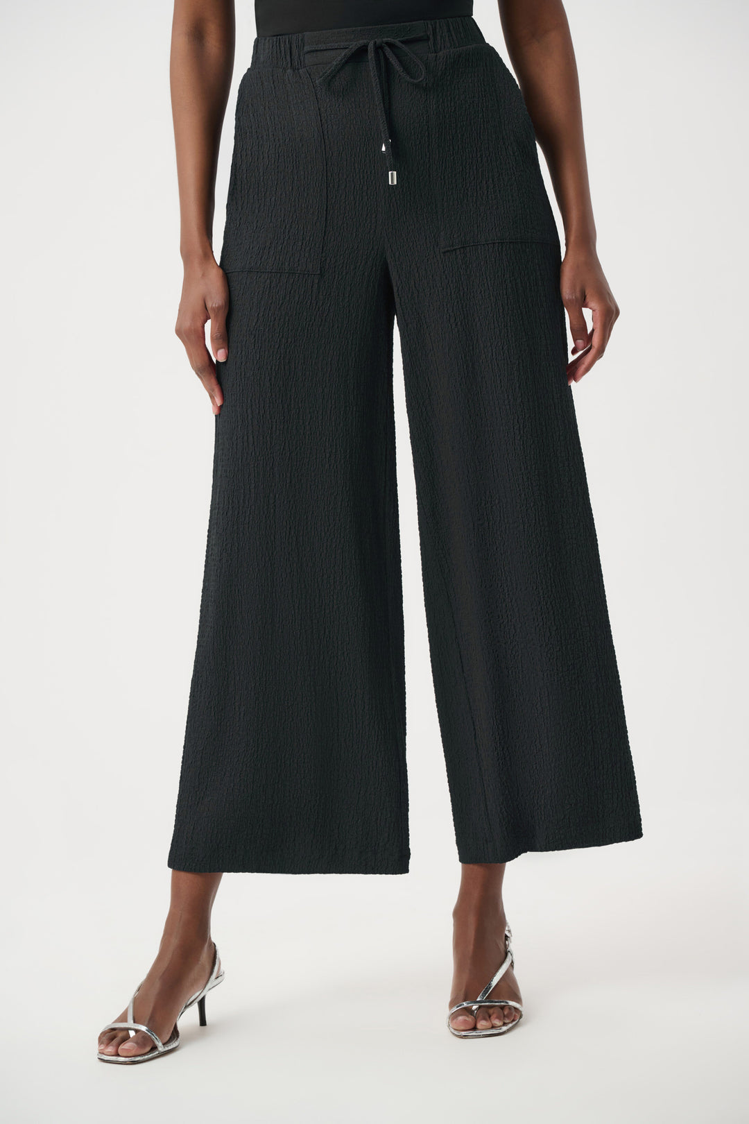 Black wide-leg pants worn by a person on a white background