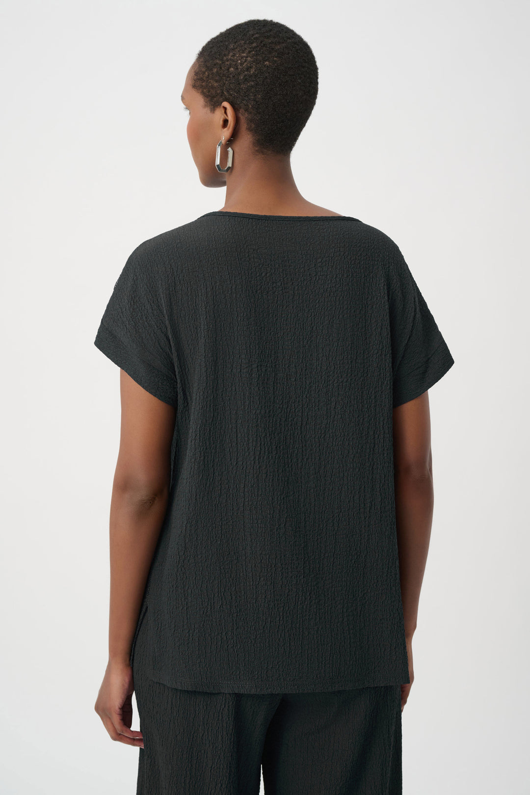 Person wearing a black t-shirt and pants on a white background