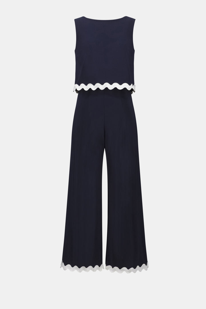 Navy jumpsuit with white scalloped trim on a white background