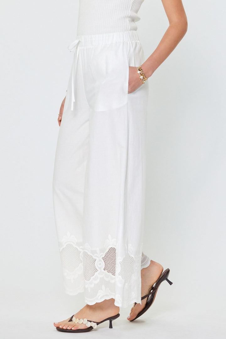 White outfit with sheer panels and sandals on a white background