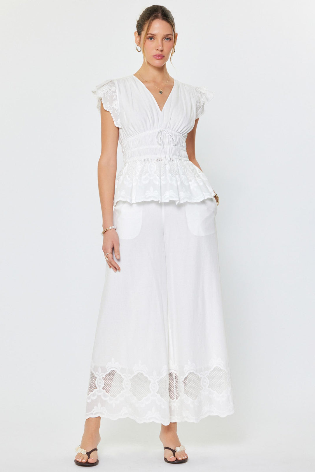 Woman wearing a white outfit with a plain background