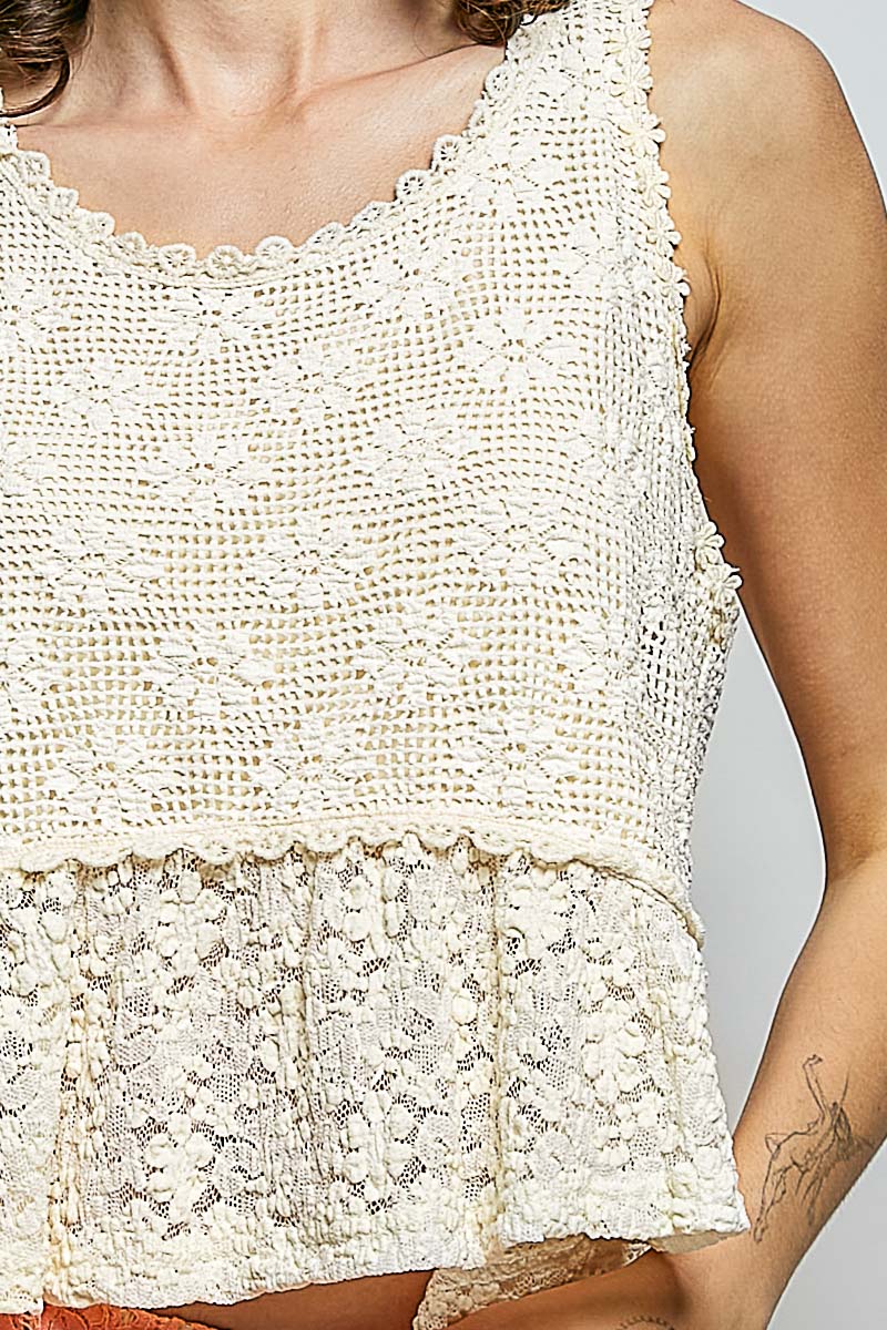 Close-up of a person wearing a textured white sleeveless top against a neutral background