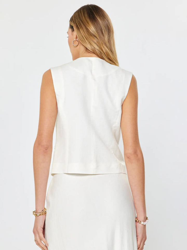 Woman wearing a white sleeveless top and skirt set on a plain background