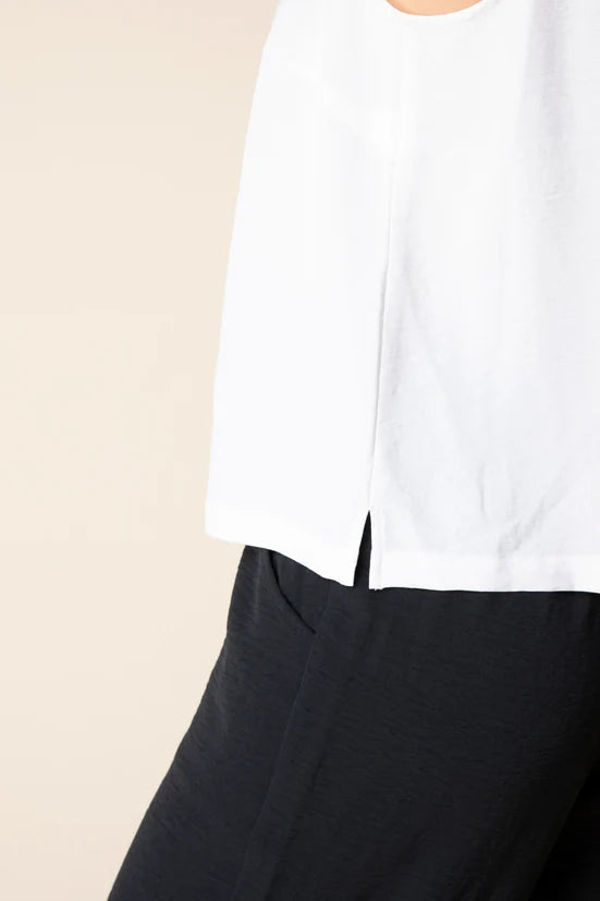 White top and black pants on a beige background
