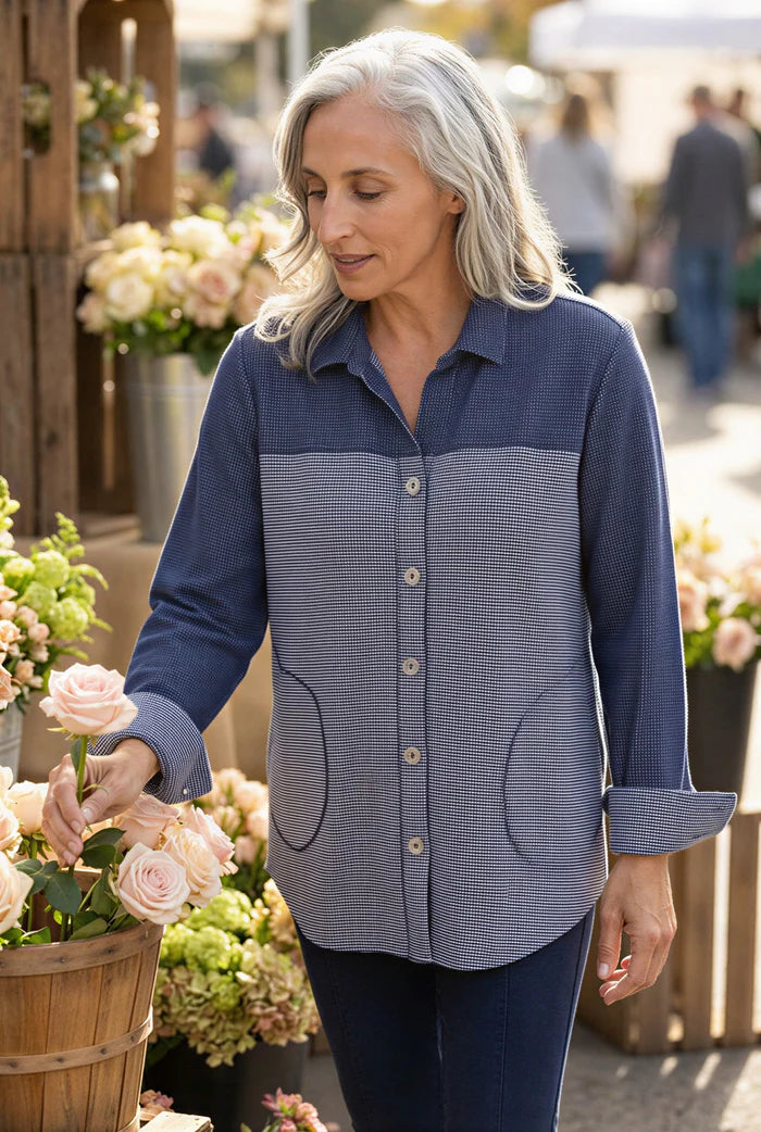 Woman in a blue shirt among flowers in an outdoor setting