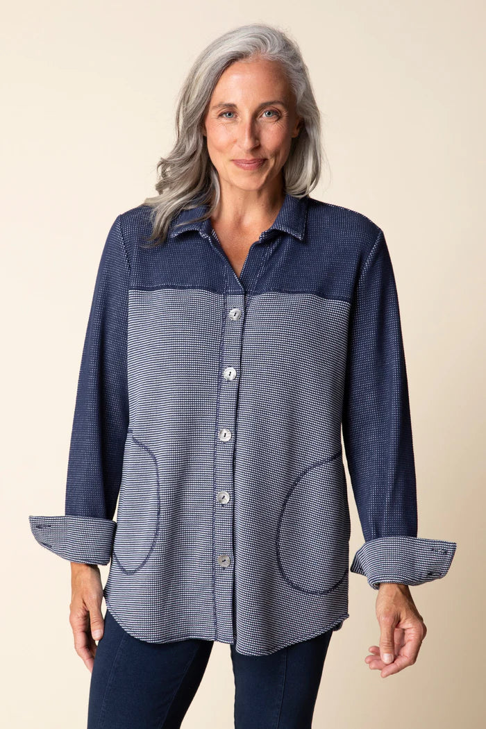 Woman wearing a blue checkered shirt with a beige background