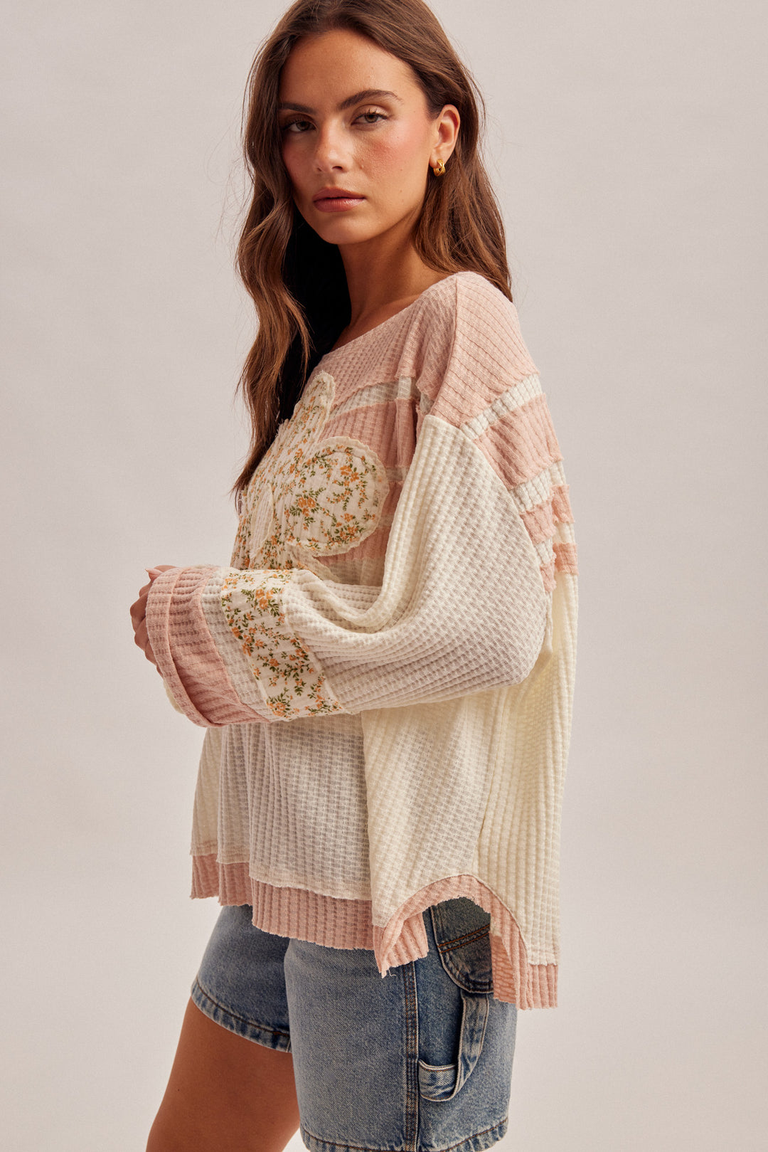 Woman wearing a floral embroidered blouse with a plain background