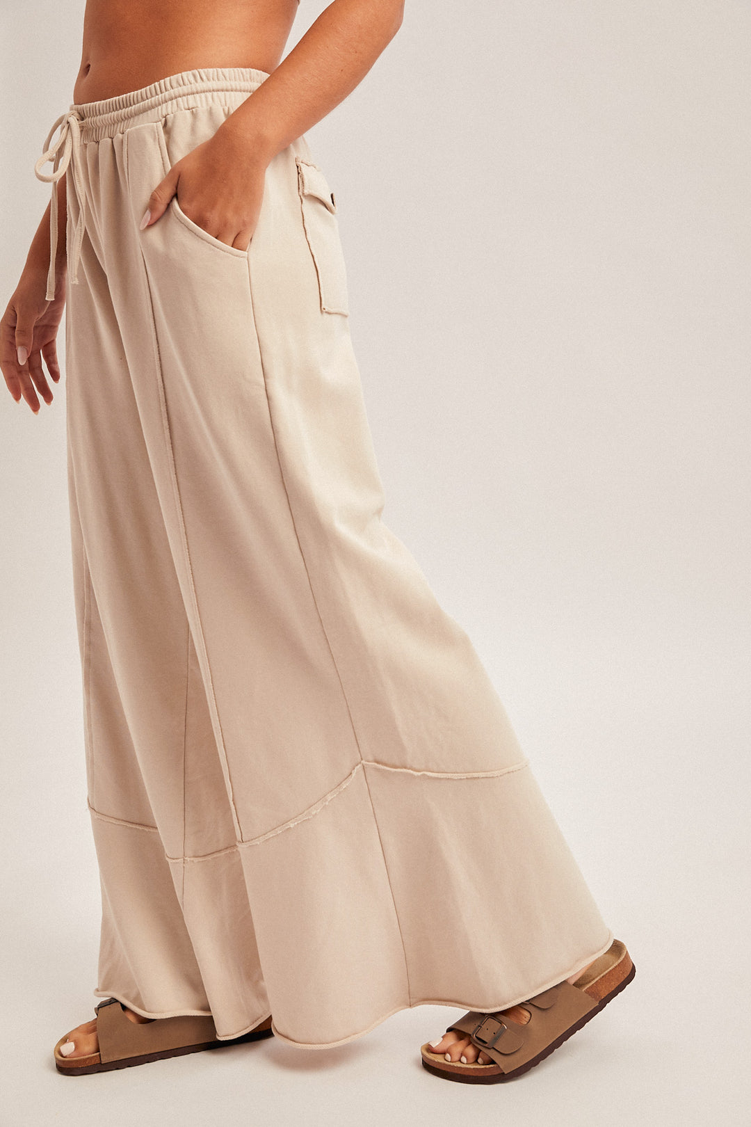 Beige wide-leg pants worn by a person on a plain background