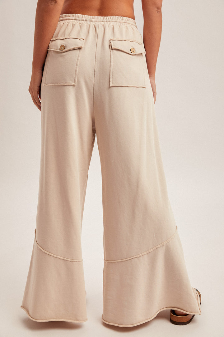 Beige wide-leg pants worn by a person on a plain background