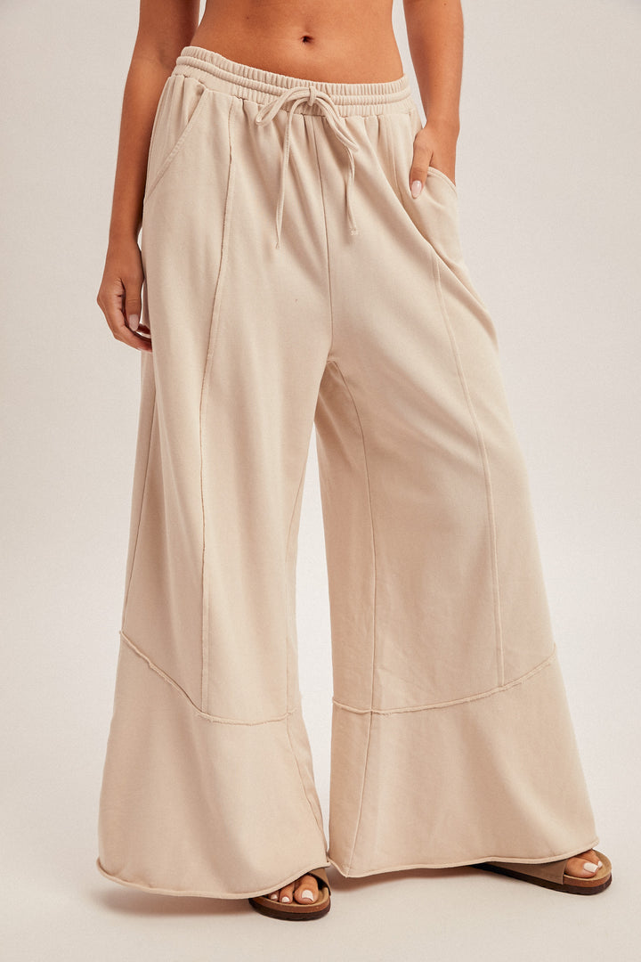 Beige wide-leg pants worn by a person on a plain background