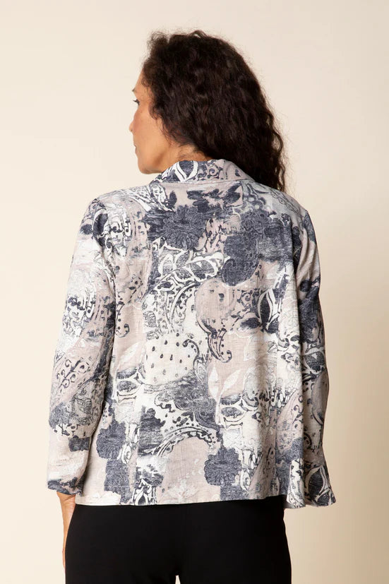 Woman wearing a floral patterned blouse against a beige background