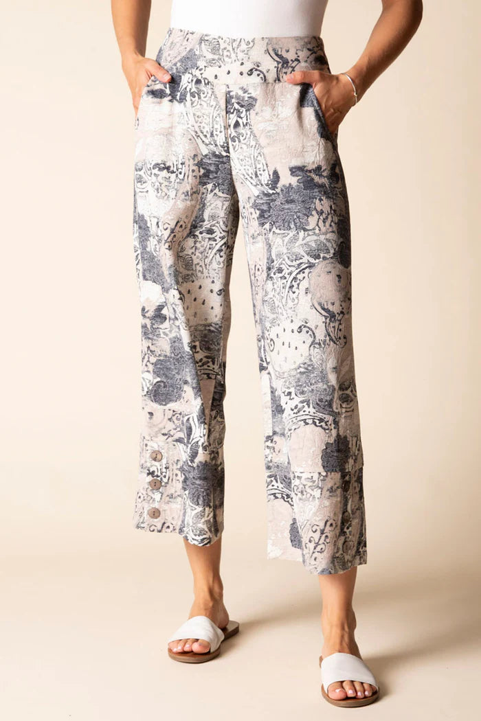Person wearing floral-patterned pants on a beige background