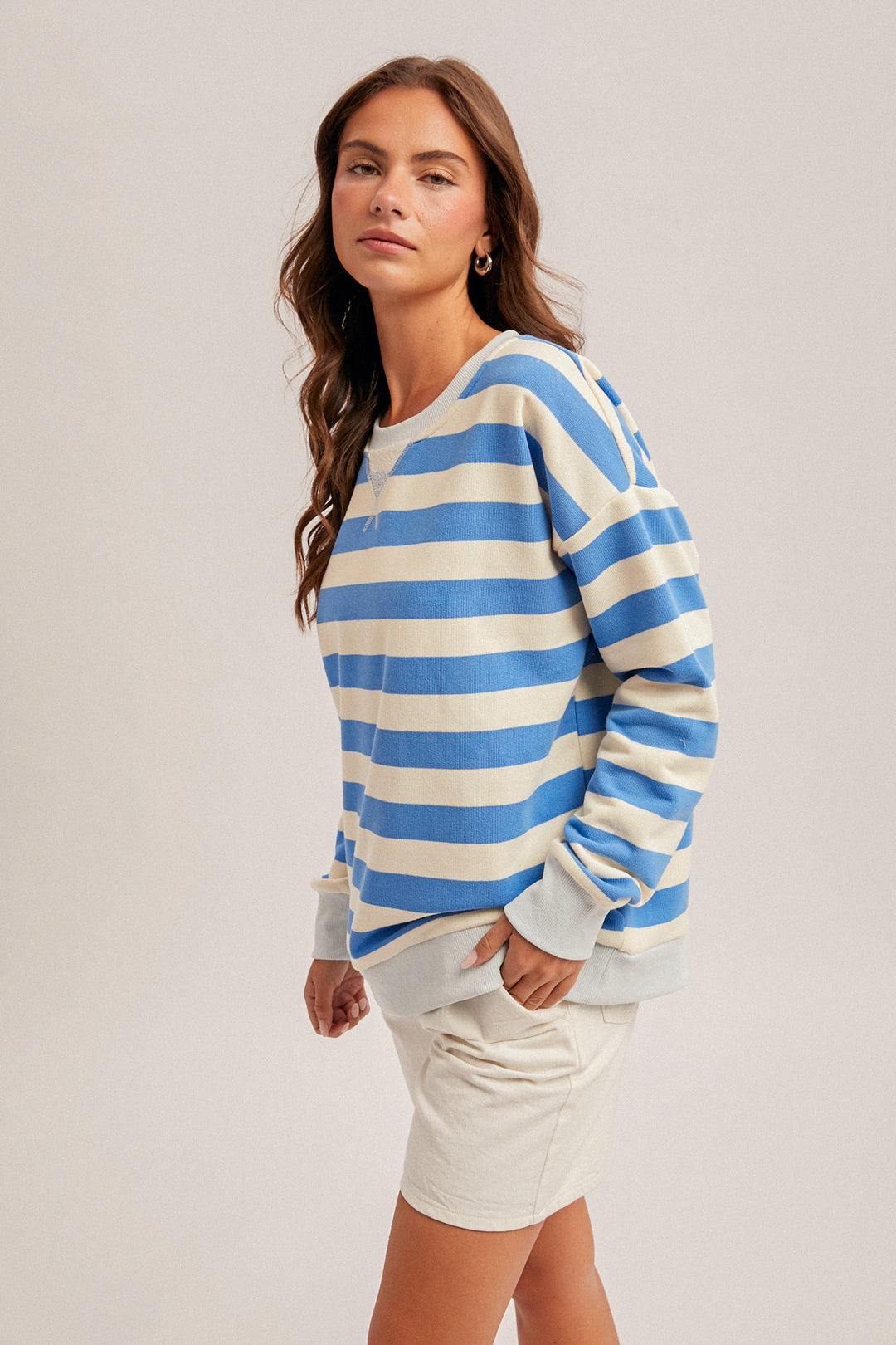 Woman wearing a blue and white striped sweater on a plain background