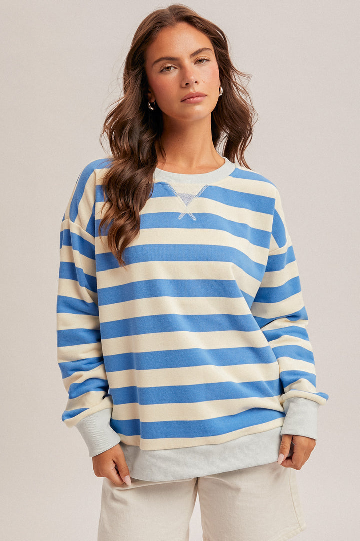 Woman wearing a blue and white striped sweater against a plain background