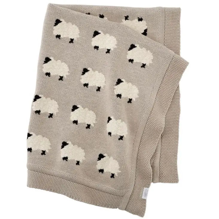 Beige knitted blanket with sheep pattern on a white background