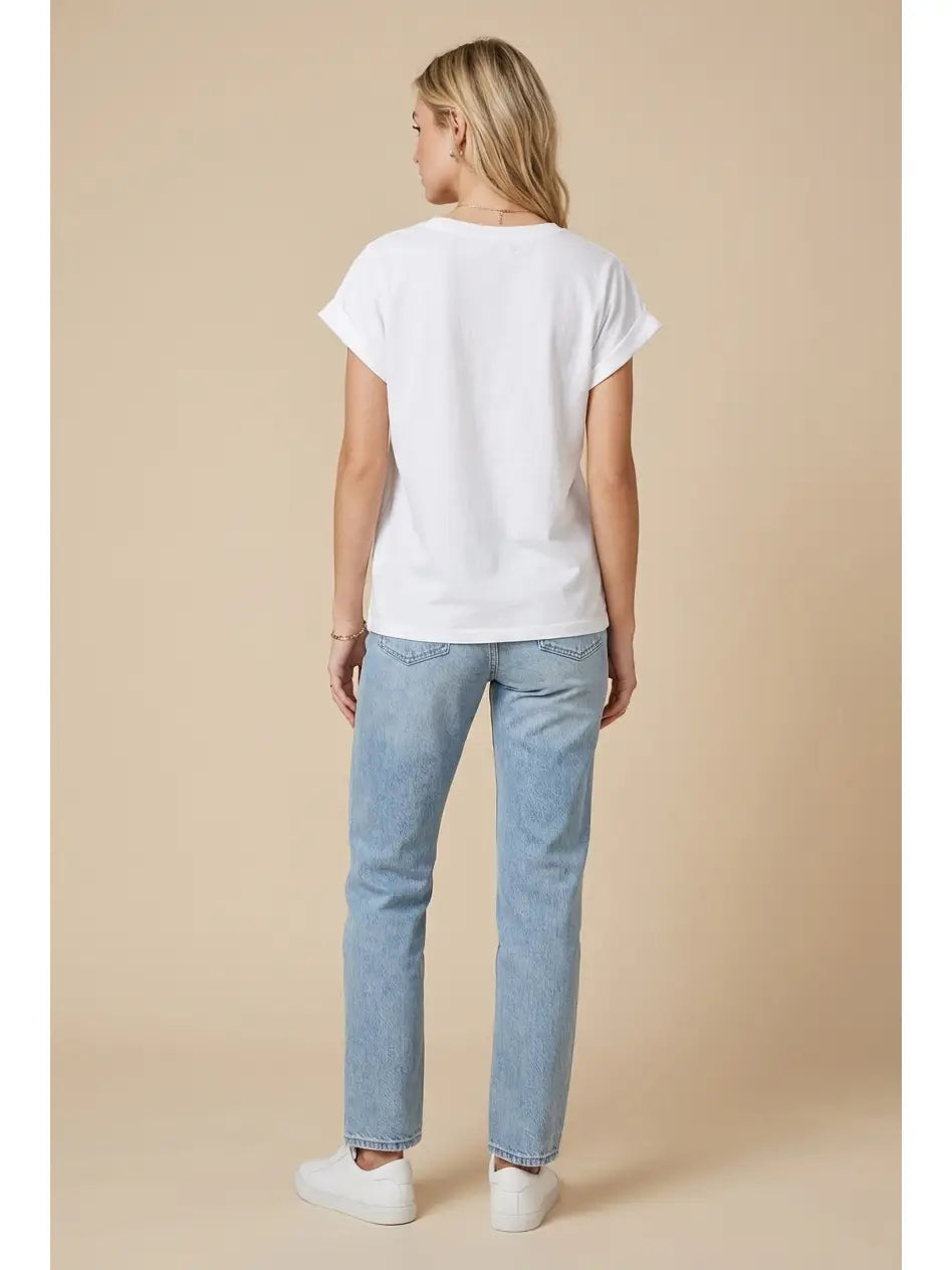 Person wearing a white t-shirt and light blue jeans on a beige background