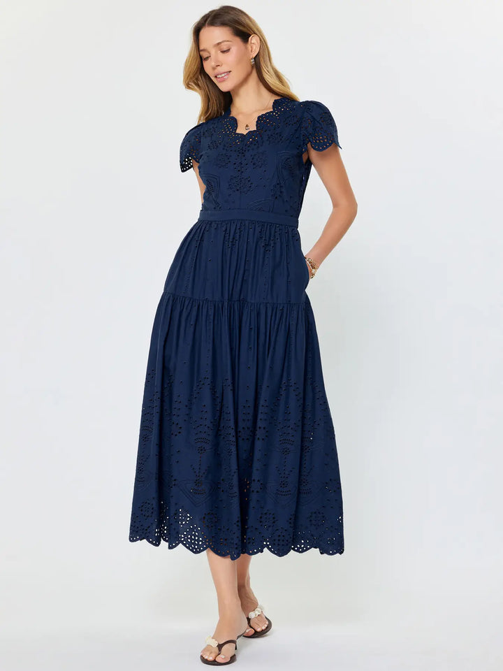 Woman wearing a navy blue lace dress on a white background