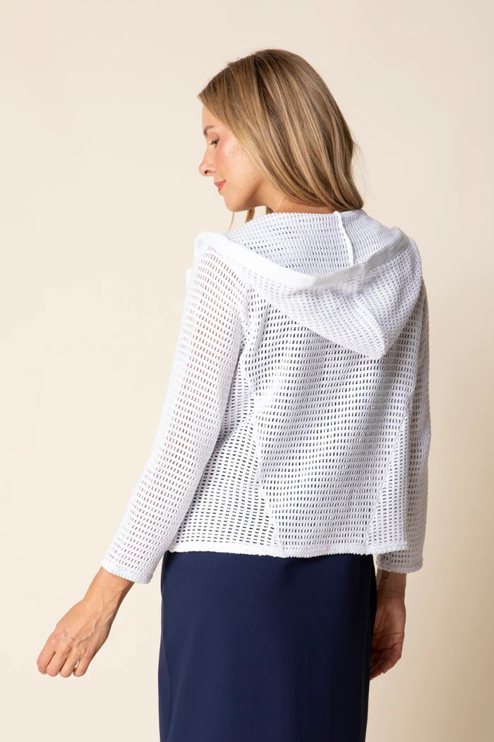 Woman wearing a white textured jacket against a beige background