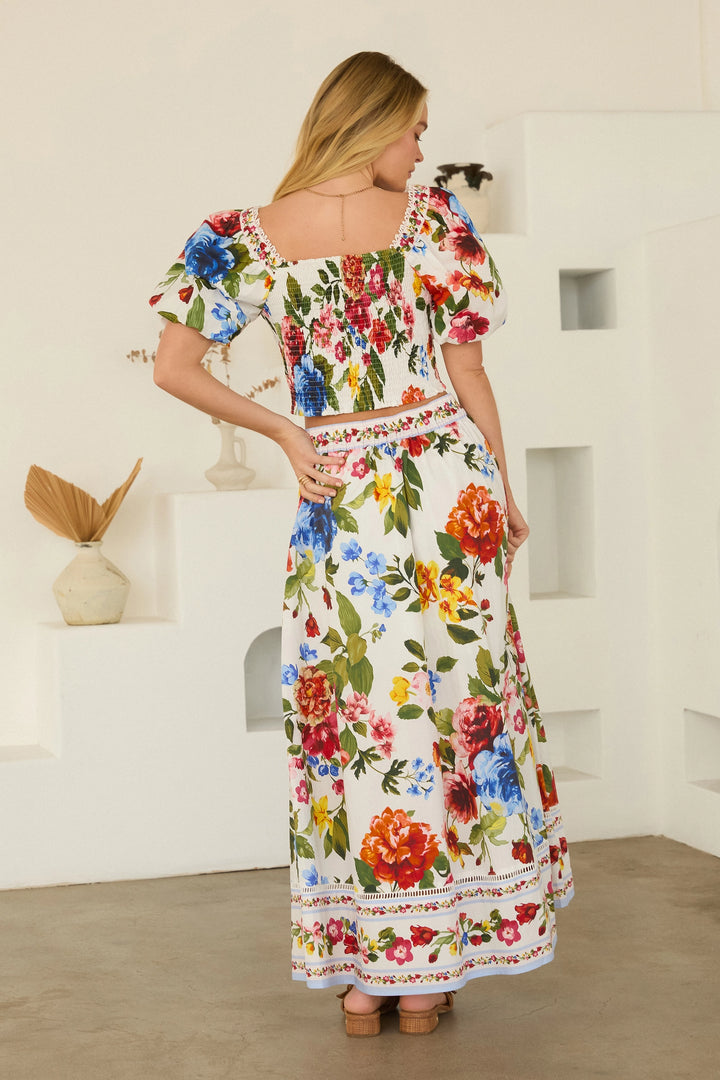 Woman wearing a floral dress in a minimal indoor setting