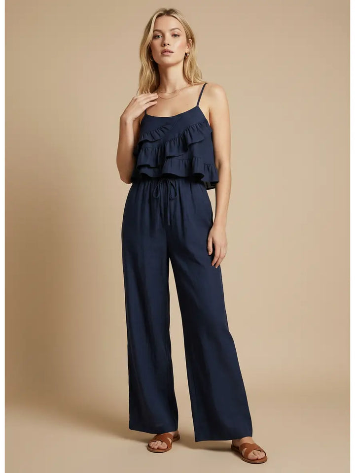 Woman wearing a navy blue jumpsuit on a beige background