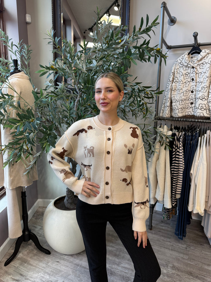 Best in Show Cardigan in cream with dog motifs and contrast buttons, waist-up front view