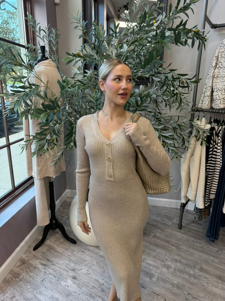 Rory Ribbed Sweater Dress in beige with V-neck and gold button placket, front view styled with woven tote