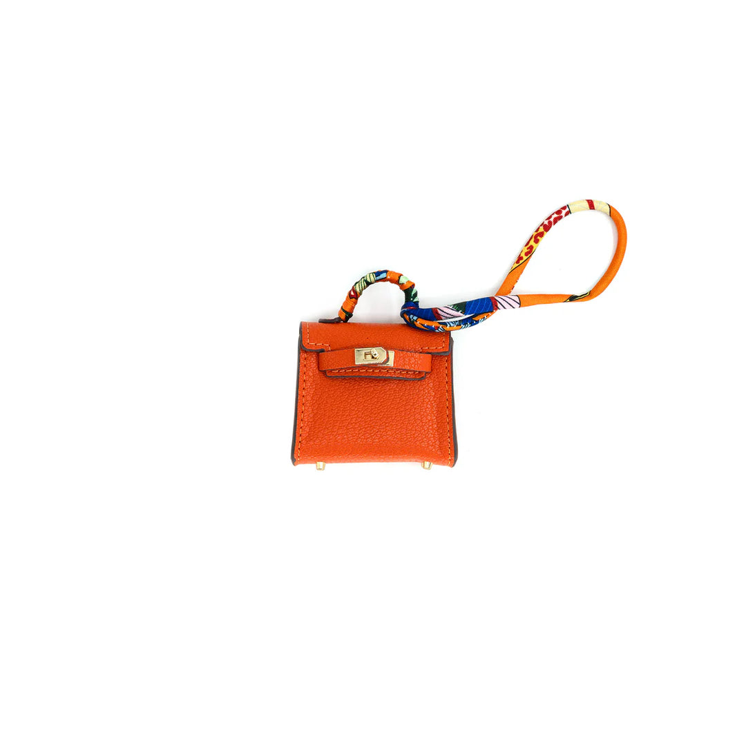 Orange leather keychain with a colorful strap on a white background