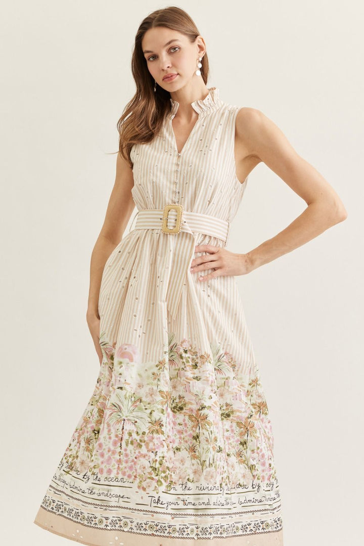 Woman wearing a sleeveless dress with floral pattern and belt on a plain background
