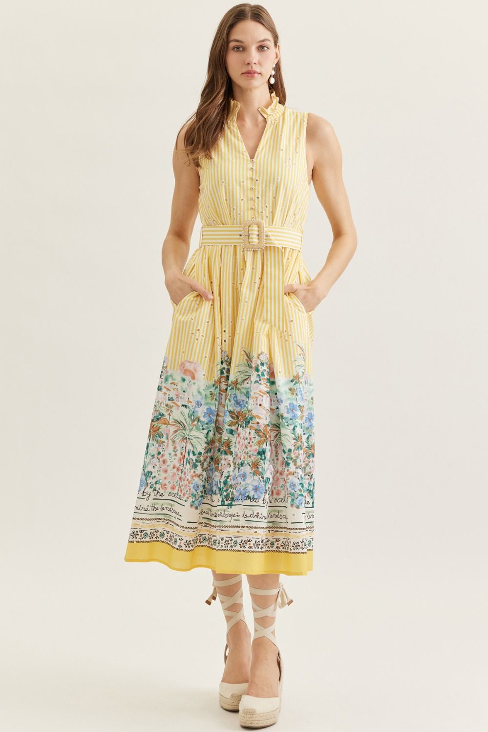 Woman wearing a yellow dress with a floral pattern on a white background