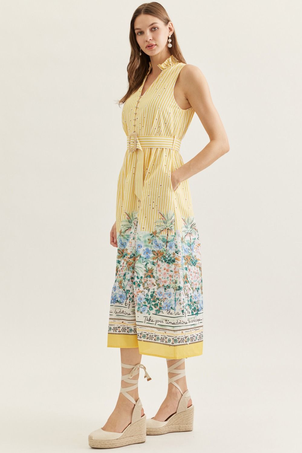 Woman wearing a yellow dress with floral pattern on a white background