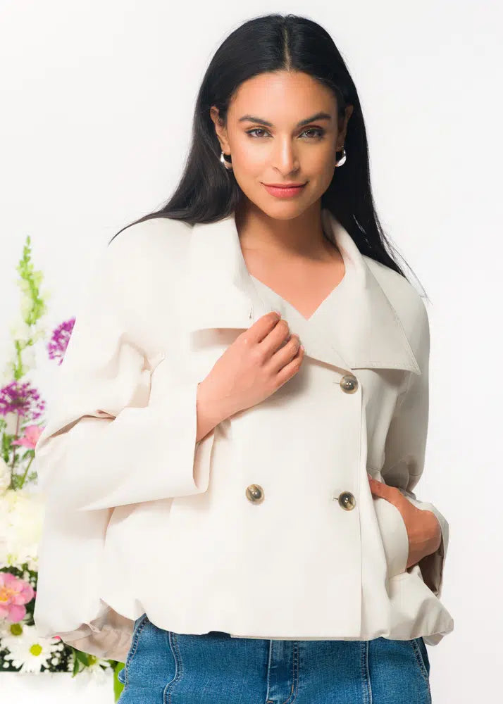 Woman wearing a white jacket with floral decorations in the background