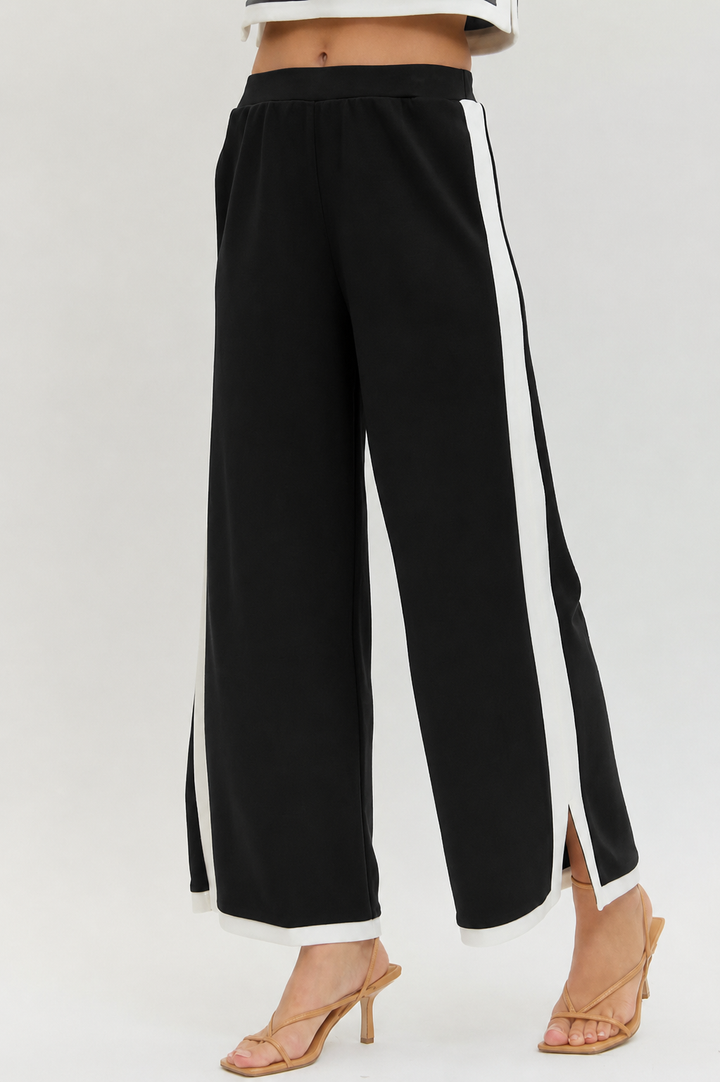 Black wide-leg pants with white stripes on a white background