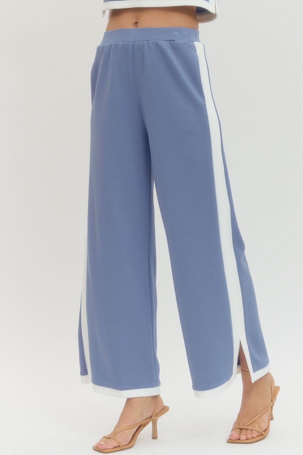 Blue pants with white side stripes on a light gray background