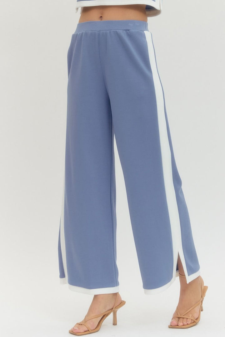 Blue pants with white side stripes on a light gray background