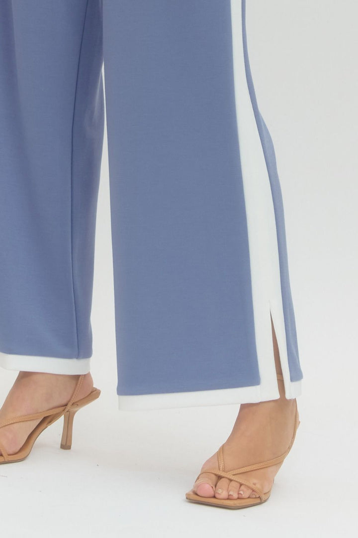 Blue pants with white trim worn by a person on a white background