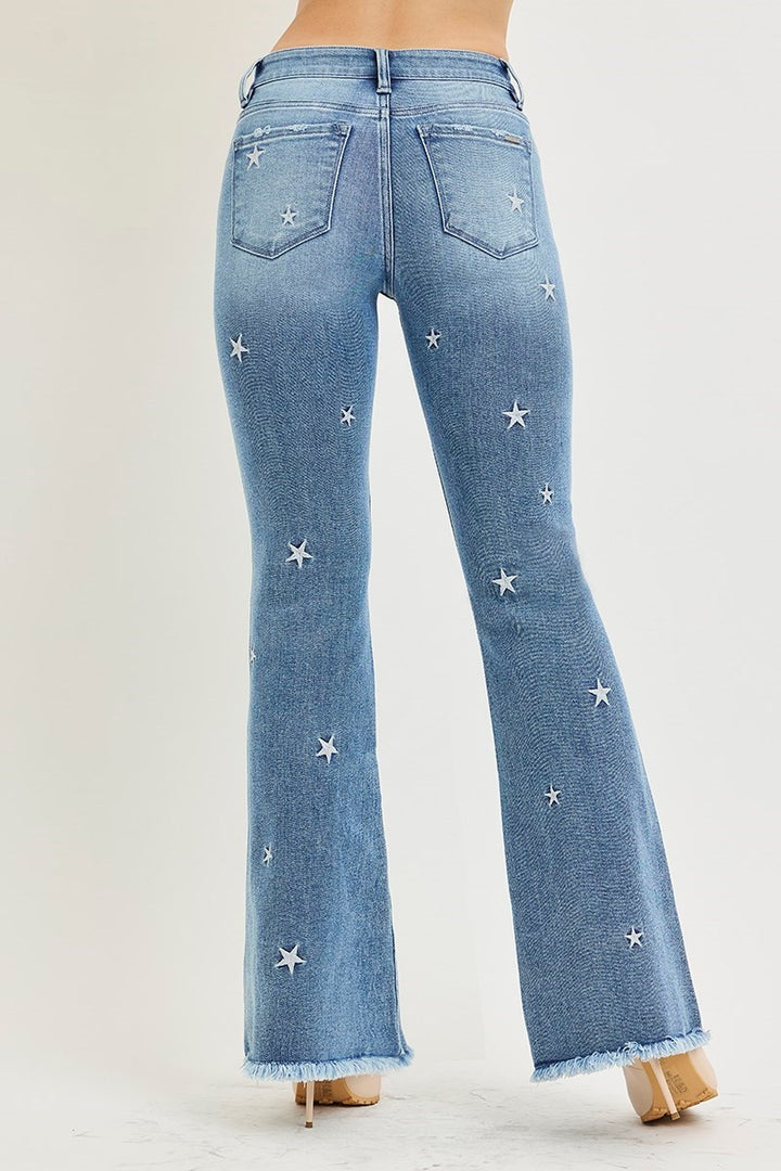Blue jeans with star embellishments on a white background