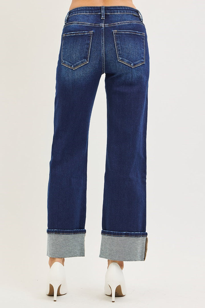 Blue jeans with cuffed ankles on a white background