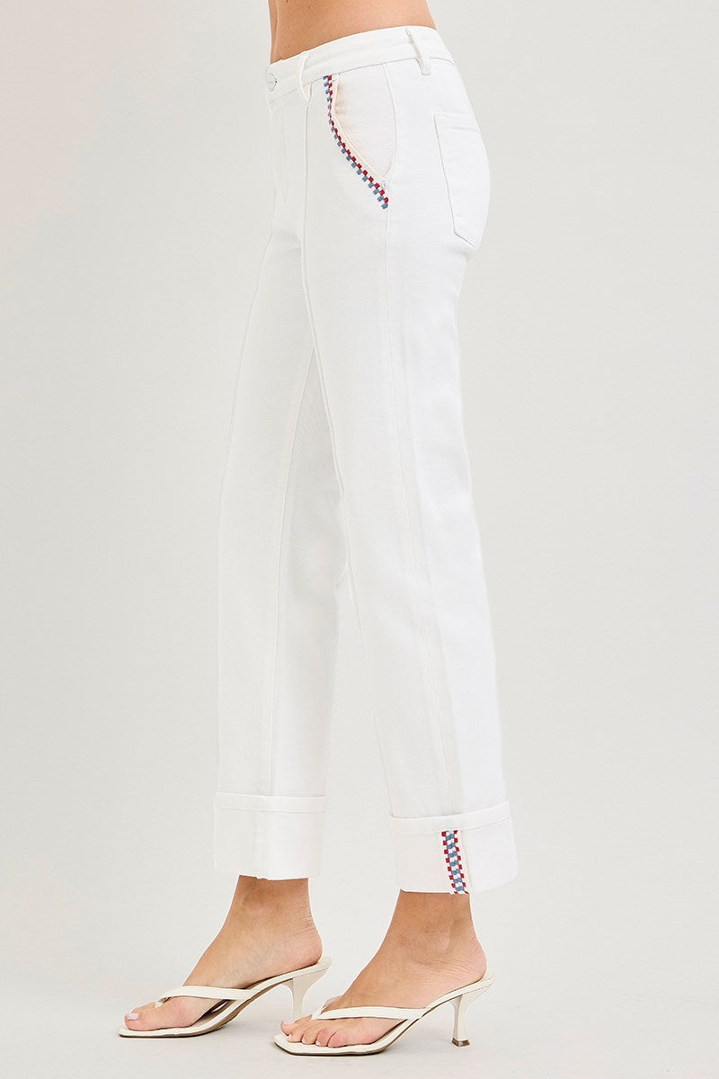 White pants with decorative hem on a white background