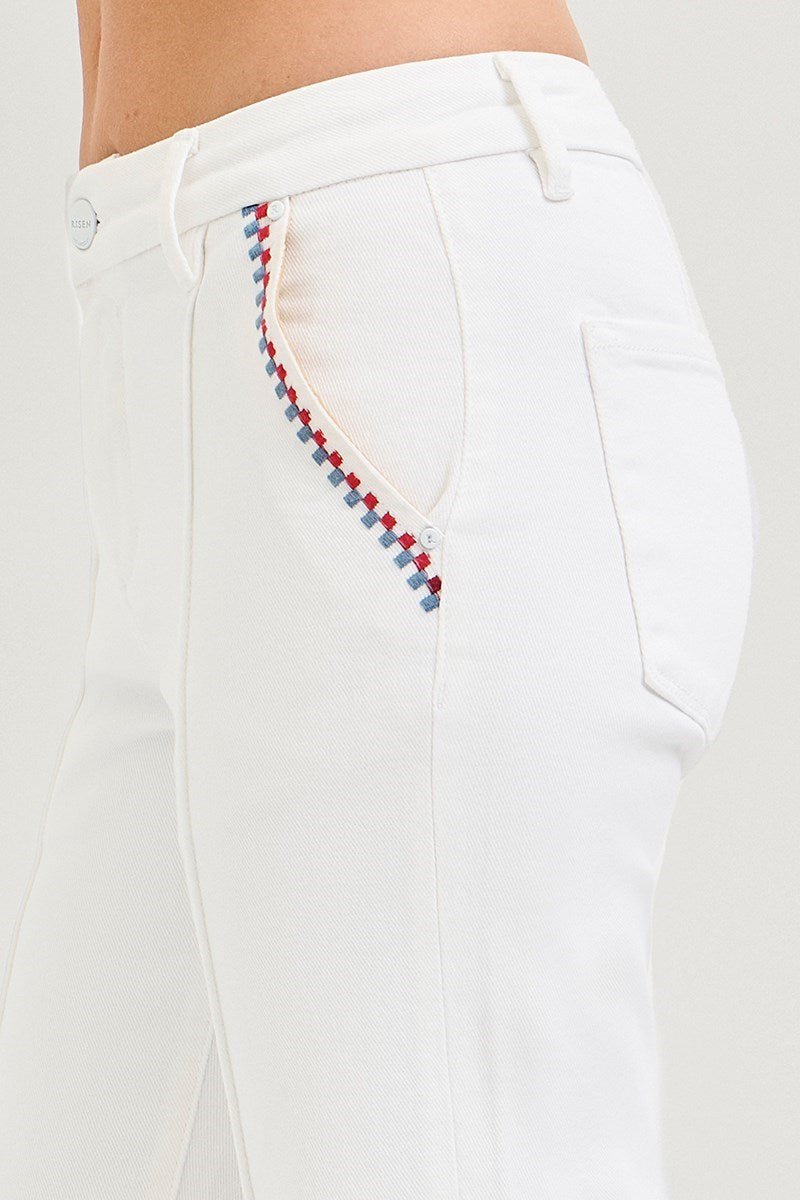 White pants with colorful stitching detail on a white background