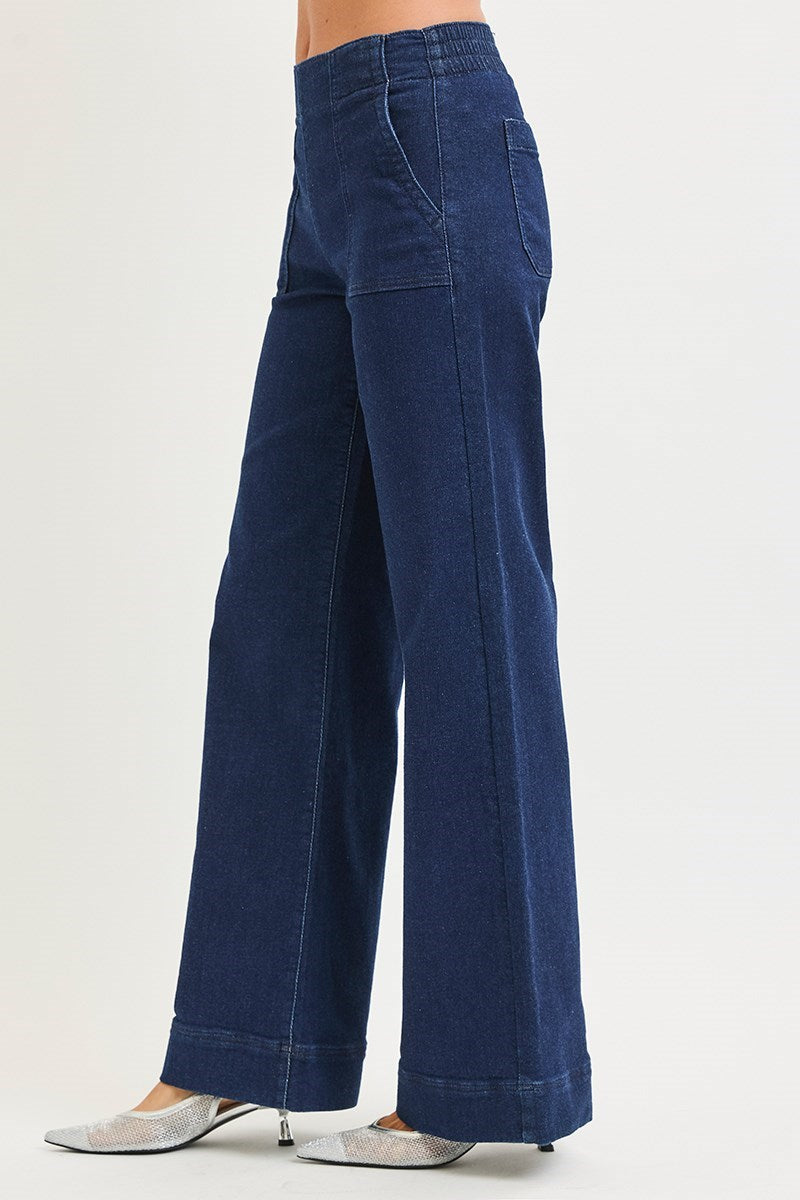 Blue wide-leg jeans worn by a person on a white background