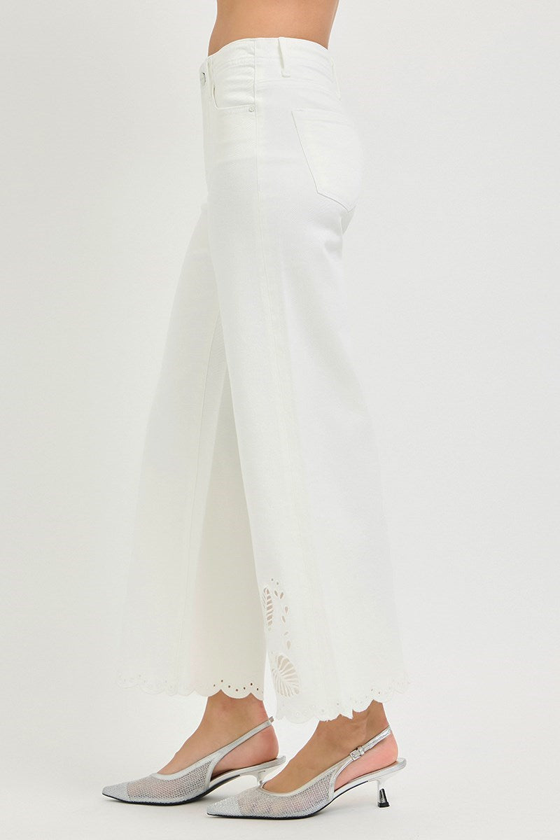 White pants with lace detailing worn by a person on a white background