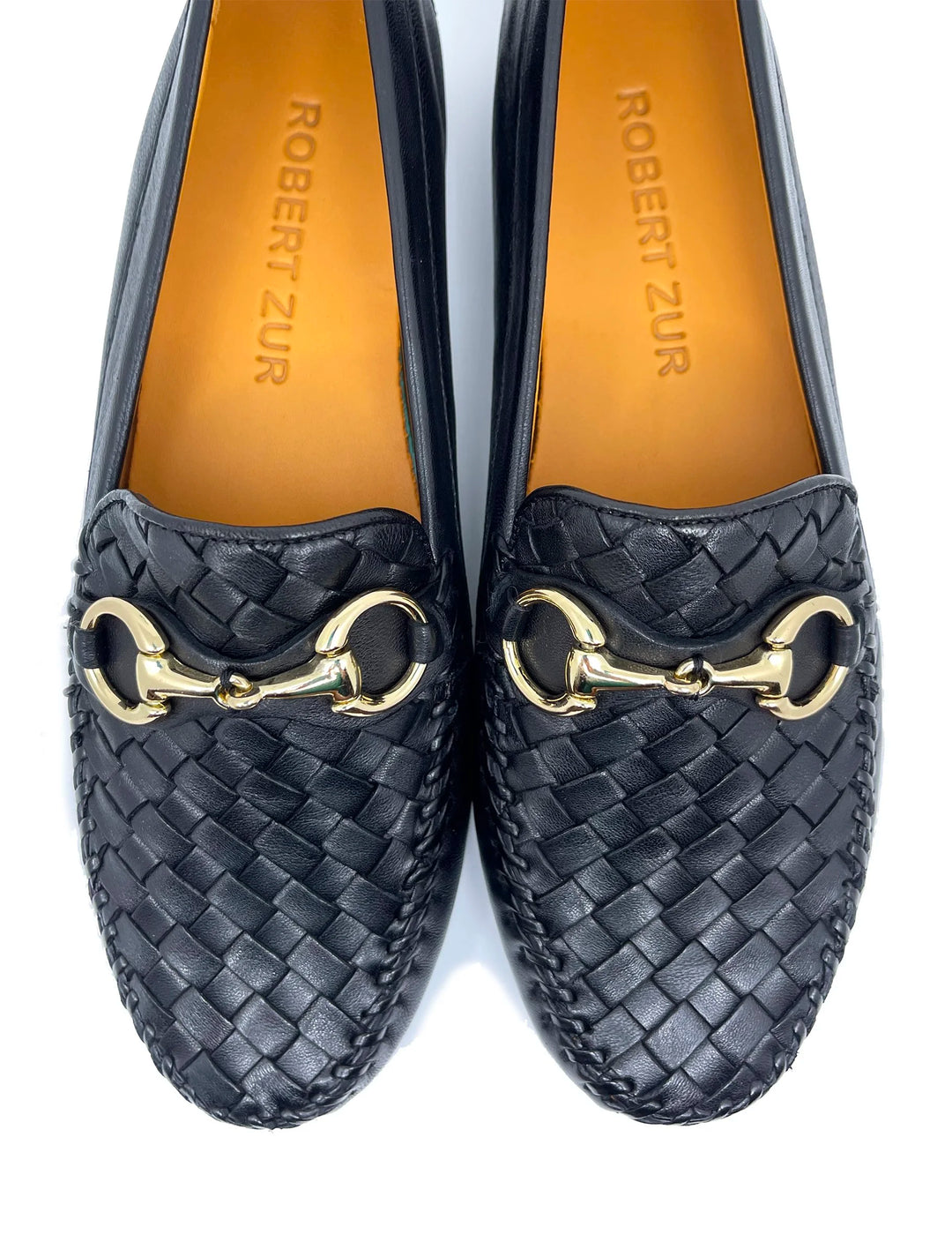 Pair of black woven loafers with gold accents on a white background