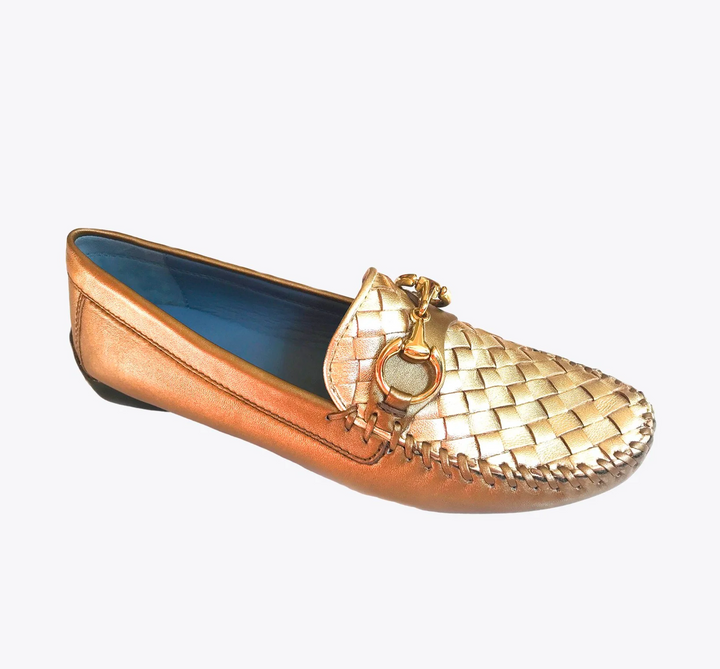 Gold loafer shoe with woven design on a white background