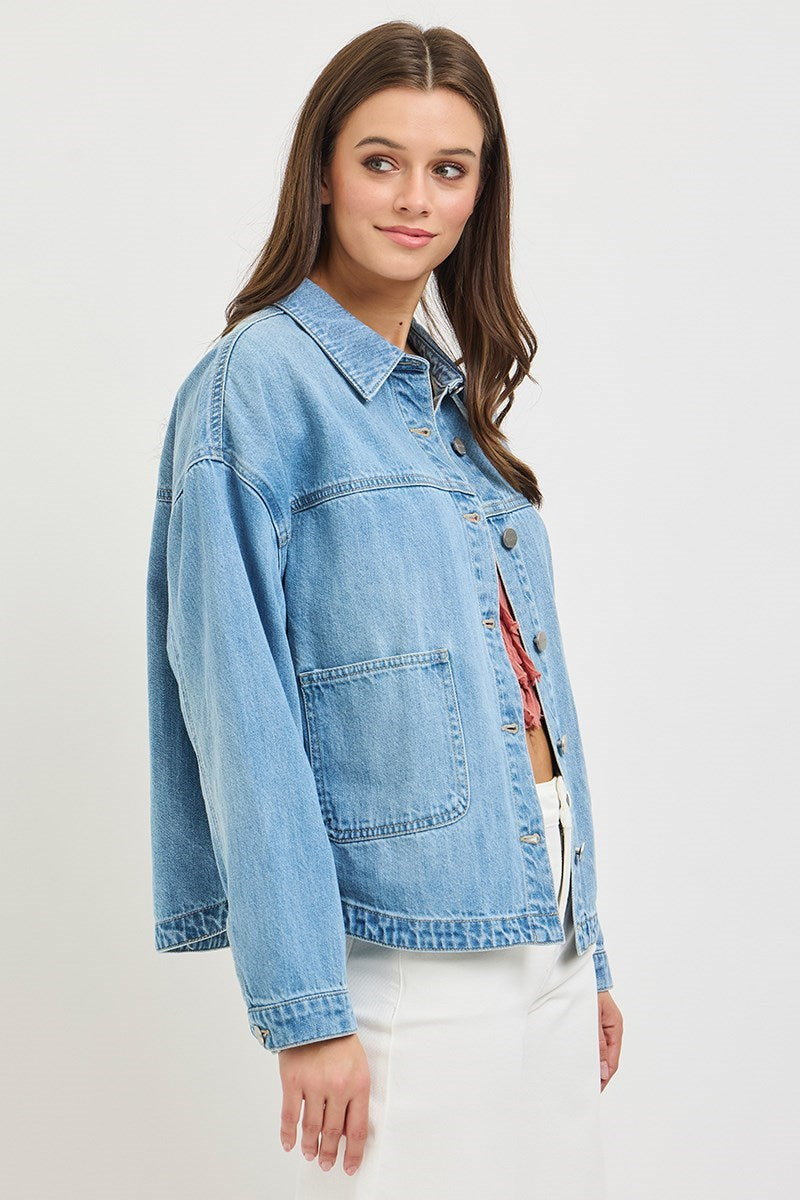 Woman wearing a light blue denim jacket on a white background