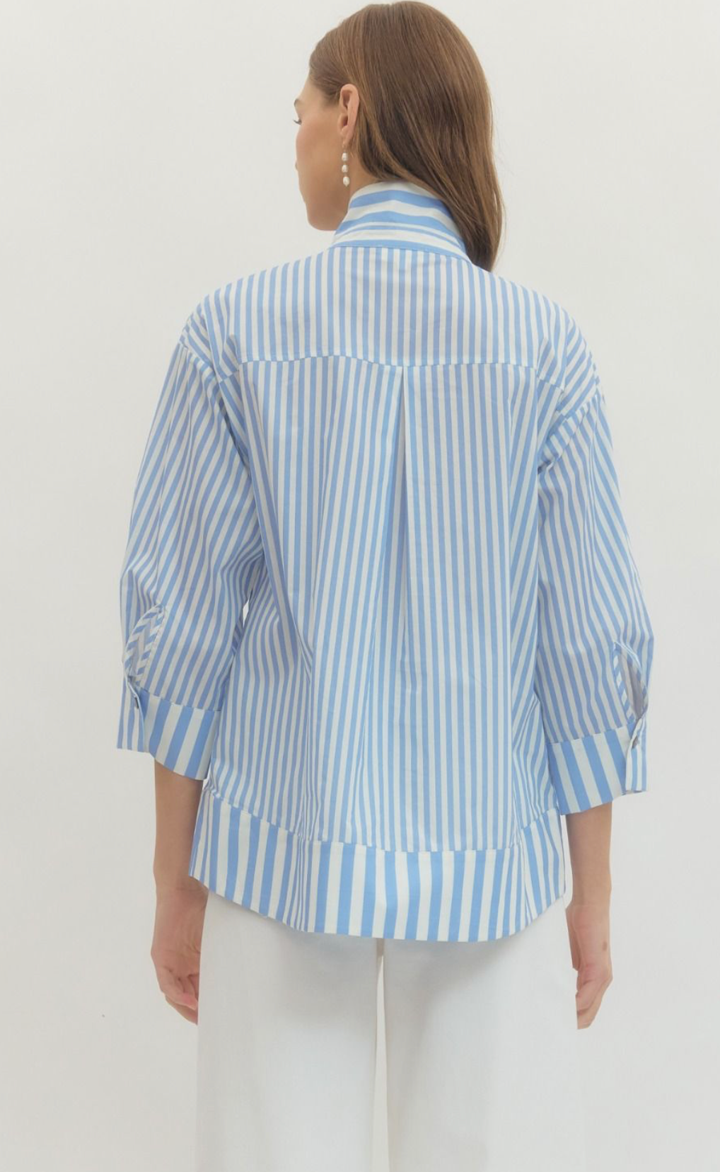 Person wearing a blue and white striped shirt against a plain background