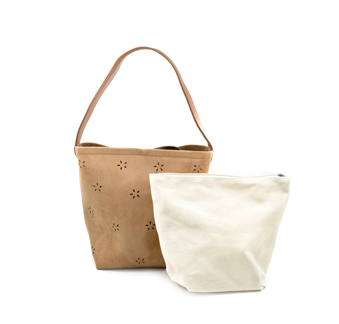 Two canvas bags, one beige with floral cutouts and one white, on a white background.